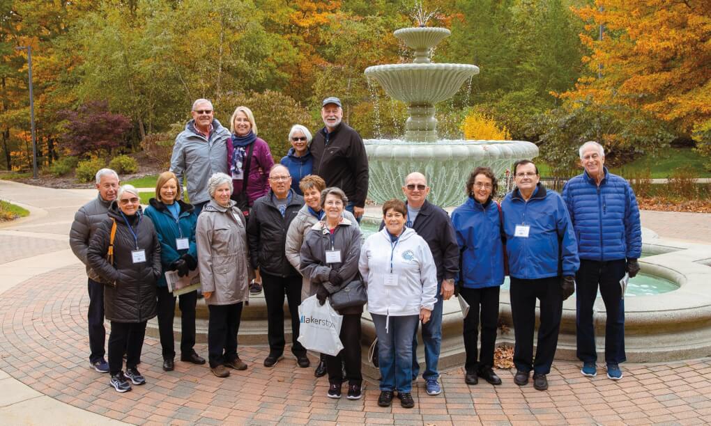 Group of Alumni standing in front of the fountain on campus
